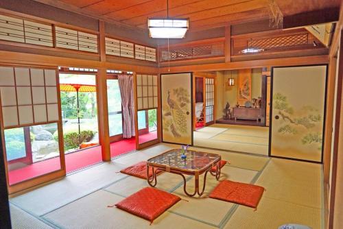 日本庭園古民家　飯田屋　Traditional experience iidayajapan في يوكوهاما: غرفة مع طاولة وبعض النوافذ