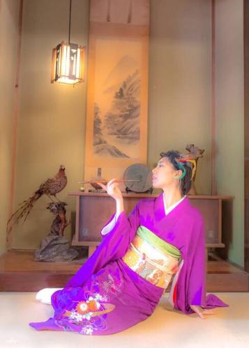 a woman in a purple dress sitting on the floor at 日本庭園古民家　飯田屋　Traditional experience iidayajapan in Yokohama