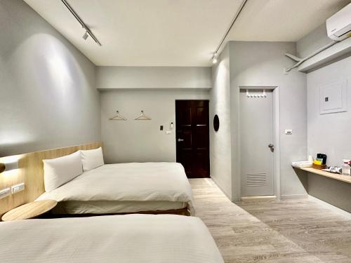 a small bedroom with two beds and a bathroom at 澄居 live in in Taichung