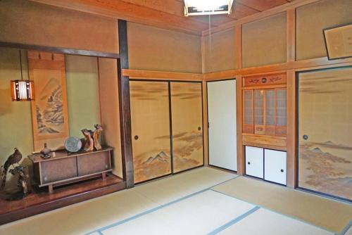 a room with glass doors and paintings on the wall at 日本庭園古民家　飯田屋　Traditional experience iidayajapan in Yokohama