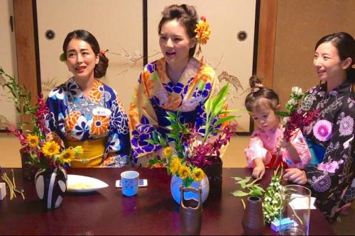 a group of three women sitting at a table with flowers at 日本庭園古民家　飯田屋　Traditional experience iidayajapan in Yokohama