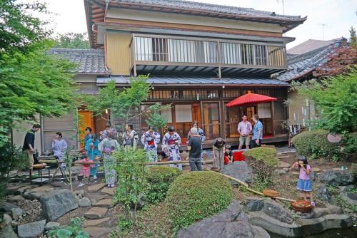 a group of people standing in front of a house at 日本庭園古民家　飯田屋　Traditional experience iidayajapan in Yokohama