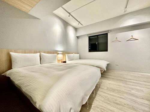 two beds in a room with a tv on the wall at 澄居 live in in Taichung
