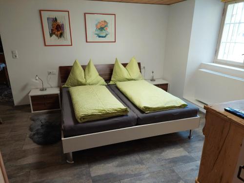 Una cama en una habitación con almohadas amarillas. en Alte Mühle, en Röthis