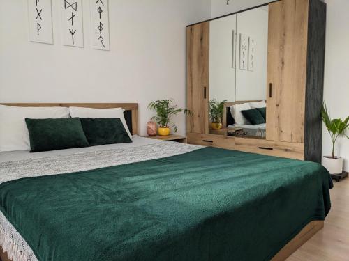 1 dormitorio con 1 cama grande con manta verde en Cozy Peacefull Apartment with amazing view en Stara Zagora