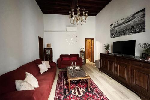 a living room with a red couch and a flat screen tv at Da Mario in Florence Guesthouse in Florence