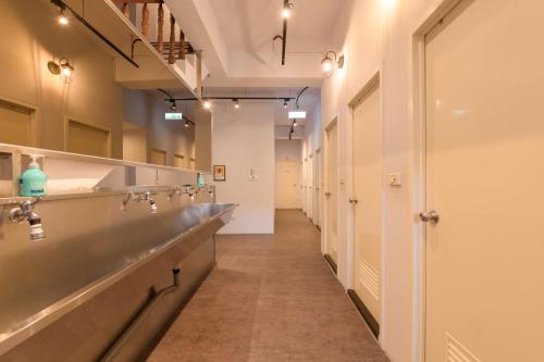 a long corridor with a row of sinks in a bathroom at On My Way Hualien Hostel in Hualien City