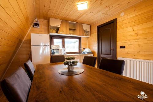einen Esstisch mit Stühlen und einen Kühlschrank in der Unterkunft Transylvania Apartments in Borzont