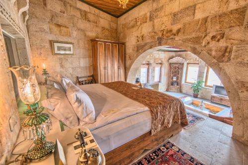 sypialnia z łóżkiem w kamiennej ścianie w obiekcie Museum Hotel w mieście Uçhisar