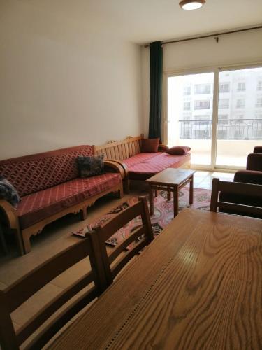 a living room with a couch and tables and a window at شالية بقرية بالميرا in Ain Sokhna