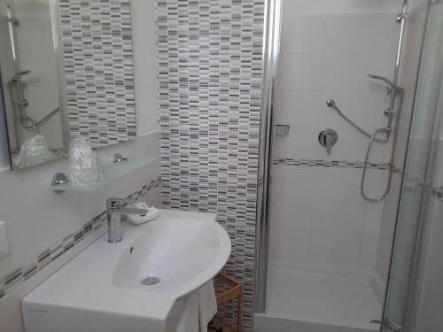 a white bathroom with a sink and a shower at Residence Le Isole in Marsala
