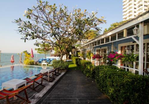 a building with benches next to a swimming pool at Pattaya Paradise Beach Resort in Na Jomtien