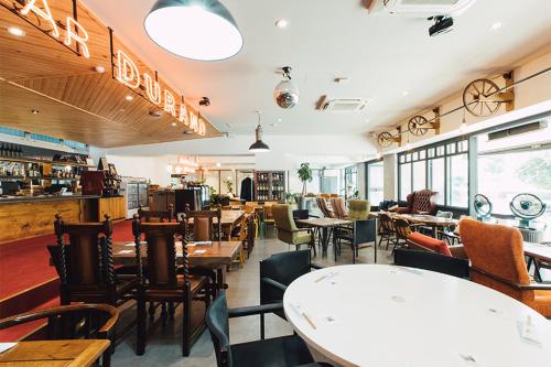 a restaurant with tables and chairs in a room at Hostel ilfaro Kurume in Kurume