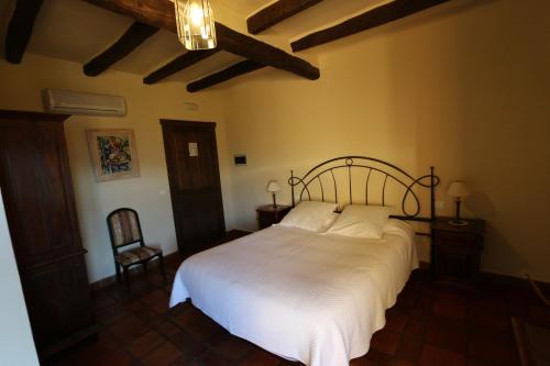 a bedroom with a large bed with white sheets at Casa Rural Rincón de la Fuente in Buenaventura