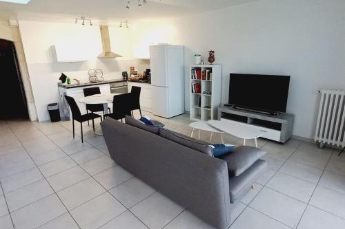 sala de estar con sofá, mesa y cocina en Le Nid - Amboise gîte semi troglodyte en Amboise