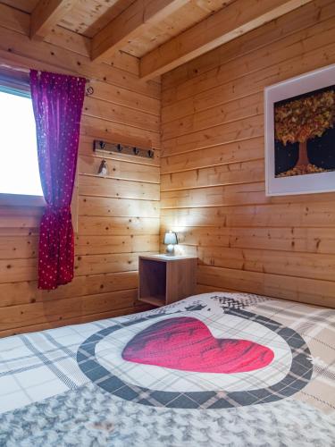 a bedroom with a bed in a wooden room at Le Chalet au vieux vignoble avec espace Sauna et Jacuzzi in Bouxwiller