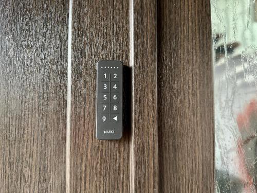 a black remote control on a wooden door at Pension Hubertus in Bad Steben