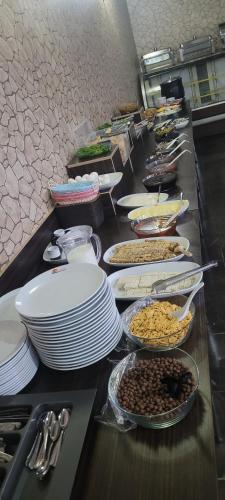 een buffetlijn met borden en kommen met eten bij Güngören Hotel in Kars