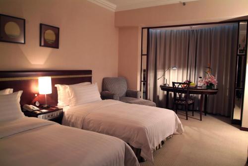 a hotel room with two beds and a desk at Rosedale Hotel & Suites Guangzhou - Free Shuttle Bus to Canton Fair in Guangzhou