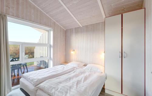 een slaapkamer met een bed en een groot raam bij Friedrichskoog-strandpark 16 in Friedrichskoog