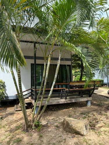 a house with a palm tree in front of it at Fine Times Resort in Ko Chang