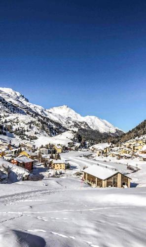 a town covered in snow with mountains in the background at Heimelige Ferienwohnung mit Sicht in die Bergwelt in Bivio