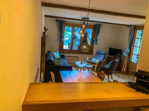 a living room with a table and a couch at Heimelige Ferienwohnung mit Sicht in die Bergwelt in Bivio