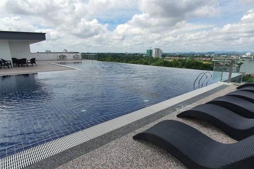a swimming pool on the roof of a building at Lovely Kozi Square Studio Bedroom with Pool LV5C in Kuching