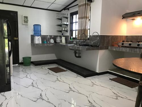 a kitchen with marble floors and a counter top at aji fruit farm in Embilipitiya