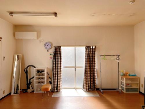 甲府市にある富竹民泊の窓とカーテンが付いた空の部屋