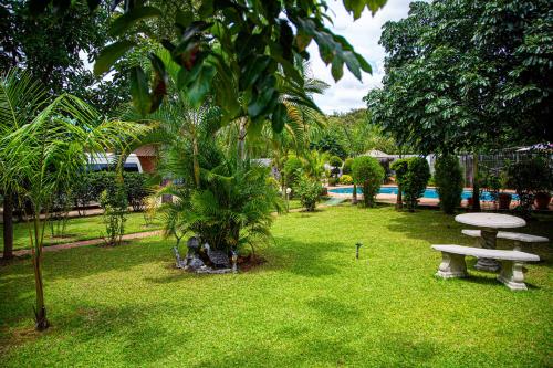 a park with a bench and a table in the grass at Dzimbahwe Guest Lodge in Victoria Falls