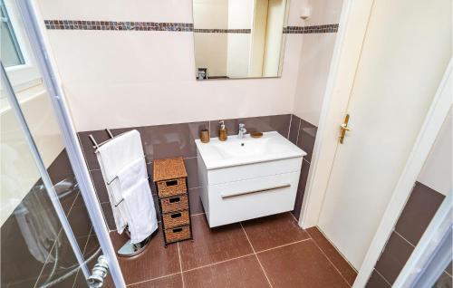 La salle de bains est pourvue d'un lavabo blanc et d'un miroir. dans l'établissement Cozy Apartment In Labin With Wifi, à Labin