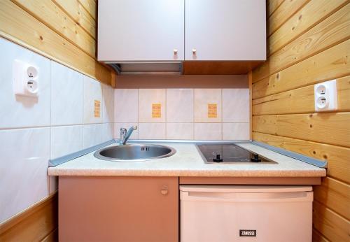 uma cozinha com um lavatório e uma bancada em Domki Letniskowe Patryk - 300m od plaży em Darlowko