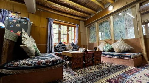 a room with couches and a table and windows at Hidden Leaf Homestay in Leh