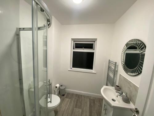 a bathroom with a sink and a toilet and a mirror at Kingsway Lounge - Accomodation for Nuneaton Contractors & Industrial estate - Free Parking & WIFI Sleeps up to 7 people in Nuneaton