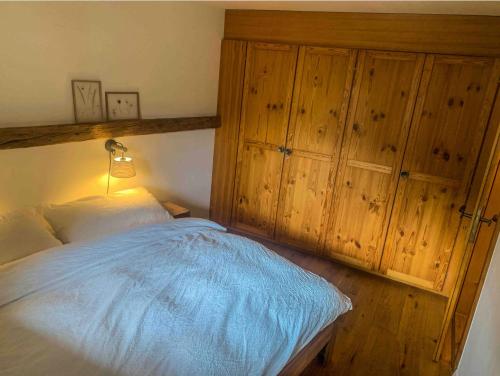 a bedroom with a bed and wooden cabinets at Heimelige Ferienwohnung mit Sicht in die Bergwelt in Bivio