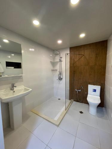 a bathroom with a toilet and a shower and a sink at Moss Art Boutique Hotel in Baku