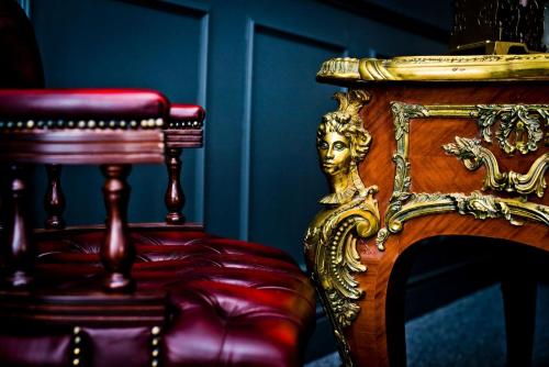 a bench and a chair with a gold head on it at Plas Dinas Country House in Caernarfon