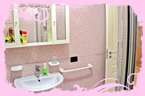 ガリポリにあるCasa Mareggiata Gallipoliのピンクのバスルーム(シンク、鏡付)