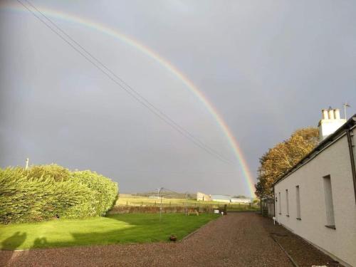 a rainbow is in the sky over a house at Dunes View, Cottage1, Dunnetbay accommodation in Castletown