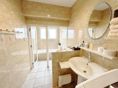 a bathroom with a sink and a shower and a mirror at Ocean Villa Tin Gala in Onna