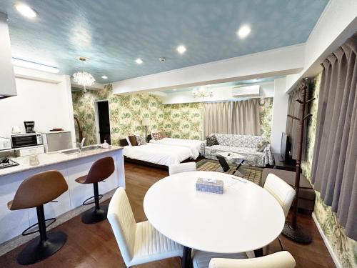 a living room with a white table and a kitchen at Ocean Villa Tin Gala in Onna