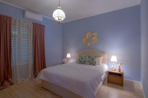 a blue bedroom with a bed and two lamps at FULLHOUSE Moudros in Moúdhros