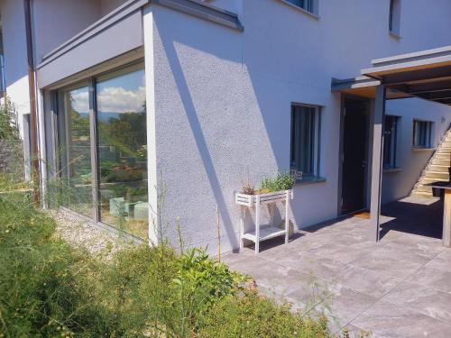 una casa azul con una mesa en el patio en Neue Wohnung an Stadtrand mit Parkplatz, en Lucerna