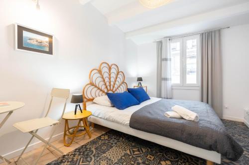 um quarto com uma cama grande e almofadas azuis em Le Petit Panier Studio 3 Clim Vieux-Port - MaisonMars em Marselha