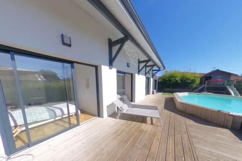 une maison avec une piscine et une terrasse dans l'établissement Superbe villa idéale pour la détente !, à Saint-Vincent-de-Tyrosse