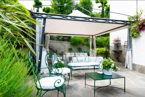 a pergola with chairs and tables on a patio at Miralago B&B and Apartments in Bellagio