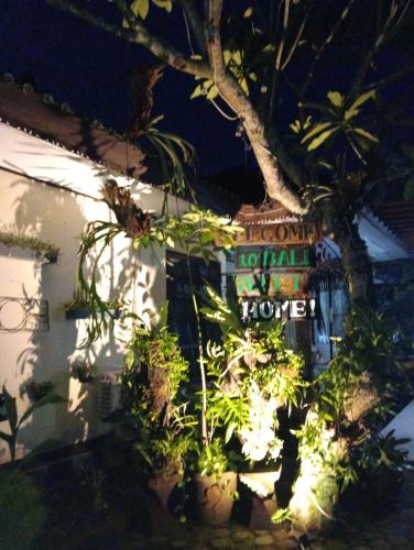a sign in front of a house with plants at Coliving Bali SWEET HOME Kost Lengkap di Tabanan Kota in Tabanan