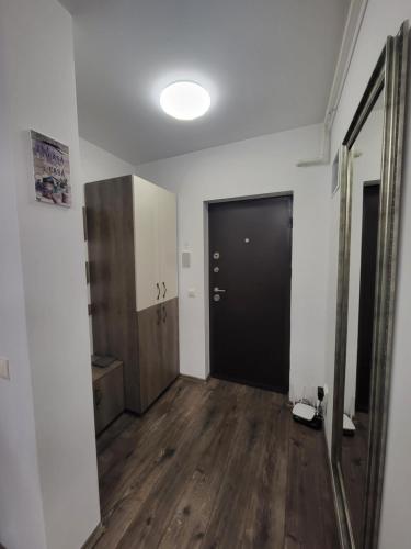 an empty hallway with a black door and wooden floors at Subcetate Residence in Bistriţa