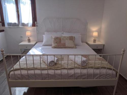 a bedroom with a bed with two tables and two lamps at Villa Beta - 5min walk to beach, BBQ, Parking in Pefkohori